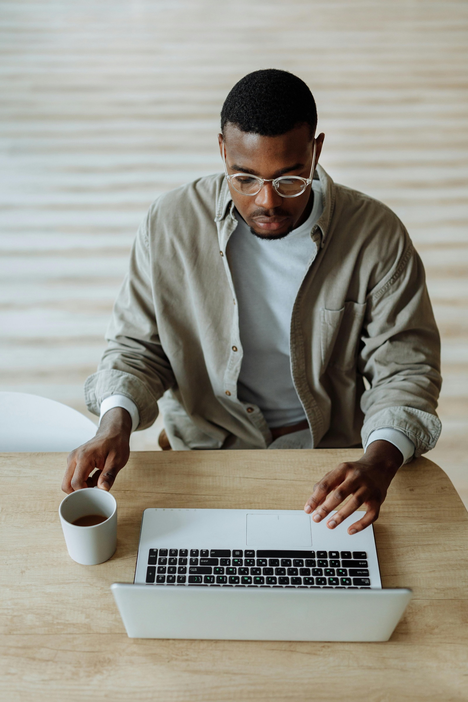 UX researcher taking notes while reviewing a user interview on a laptop
